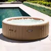An inflatable hot tub filled with bubbling water sits on a patio next to a swimming pool. Náhľad obrázku produktu