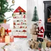 A Christmas-themed advent calendar with 24 pockets, decorated with festive ornaments and surrounded by Christmas decorations like a tree, candles, and gifts. Produktbild-Vorschau