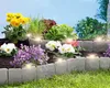 A garden bed with flowers and plants, bordered by stone-like edging with integrated lights. Produktbild-Vorschau