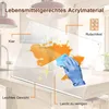 A clear acrylic cutting board is shown on a kitchen counter, with an orange liquid spilled on it and being wiped away by a gloved hand with a blue sponge. Sparkle graphics indicate cleanliness. Produktbild-Vorschau