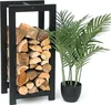 A black metal firewood rack filled with logs next to a potted green plant. Anteprima dell’immagine prodotto