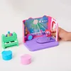 A child's hand is shown interacting with a toy music room playset. Náhľad obrázku produktu