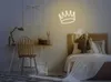 A bedroom scene with a desk and a bed, decorated with a neon crown light. Produktbild-Vorschau