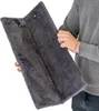 A person is holding a folded gray fuzzy scratching mat. Produktbild-Vorschau