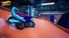 A Hot Wheels Unleashed toy car on an orange track in a dimly lit indoor environment. Produktbild-Vorschau