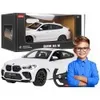 A toy BMW X6 M car and a young boy. Podgląd zdjęcia produktu
