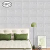 A bedroom scene with a bed, pillows, a floor lamp, and artwork on a wall covered in acoustic panels. Náhled obrázku produktu