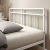 Seitenansicht des weißen Metallkopfteils mit minimalistischem Design und Kissen.
 Produktbild-Vorschau
