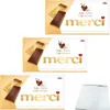 Three identical boxes of Merci coffee and cream chocolate bars are shown, along with a separate white item that appears to be a notepad or similar. Produktbild-Vorschau