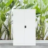 A white metal cabinet is shown in front of a lush green plant wall. Voir les images du produit