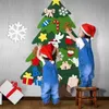 Two young children are decorating a felt Christmas tree with ornaments. Produktbild-Vorschau