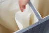 A close-up view of the inside of a multi-compartment laundry hamper, with a hand holding up the fabric lining of one compartment. Náhled obrázku produktu