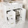 A white bathroom vanity with a sink and open cabinets filled with toiletries and towels, set against a tiled wall and floor. Anteprima dell’immagine prodotto
