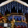 Christmas lights decorating the exterior of a house, including icicle lights on the roof and string lights on the balcony, with a nativity scene visible. Produktbild-Vorschau