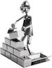 A metal figurine of a construction worker laying bricks. Náhled obrázku produktu