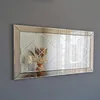 A rectangular mirror with a decorative diamond pattern is mounted on a gray wall. Produktbild-Vorschau