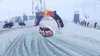 A rally car racing on a snowy track under a Red Bull arch. Produktbild-Vorschau