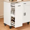 A white kitchen cart with a wooden countertop, open drawers revealing bottles and canisters, and black wheels. Produktbild-Vorschau