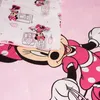 A close-up view of a pink Minnie Mouse themed bed linen with a pillowcase featuring a pattern of Minnie Mouse and buildings. Produktbild-Vorschau