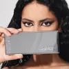 A woman is holding a makeup palette in front of her face, showing her eyes and the palette. Produktbild-Vorschau