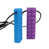 Two teething toys shaped like building blocks, one blue and one purple, on a white background. Produktbild-Vorschau