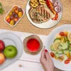 A table setting with food and a drink, featuring a wooden coaster. Produktbild-Vorschau