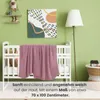 A nursery room setting with a crib and a blanket. Produktbild-Vorschau