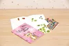 A sticker album with stickers is laid out on a wooden surface. Produktbild-Vorschau