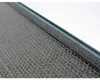 A close-up view of the edge of a mirror with a textured surface underneath. Náhľad obrázku produktu
