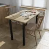 A dining table with two chairs in a bright room, set up for a meal. Produktbild-Vorschau
