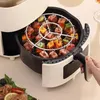 A hand is shown pulling out a rack of food from an air fryer. Náhľad obrázku produktu