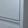 A close-up view of the side of a gray metal cabinet, showing the edge of a drawer or door and the seam between two panels. Voir les images du produit