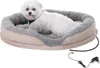 A small white dog is resting in a heated pet bed. Produktbild-Vorschau