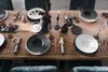 A formal dining table setting with plates, cutlery, glassware, and decorative elements. Podgląd zdjęcia produktu