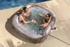 Four people are enjoying a hot tub outdoors next to a swimming pool. Produktbild-Vorschau