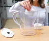 A person is inserting a water filter into a water pitcher. Produktbild-Vorschau