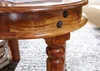 A close-up shot of a wooden table leg and edge, with a stack of books visible on the left. Produktbild-Vorschau