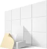 A stack of white acoustic panels with one panel peeled back to show the adhesive backing, placed in front of a wall covered in the same panels. Produktbild-Vorschau