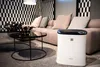 A modern living room with a couch, coffee table, and an air purifier. Podgląd zdjęcia produktu