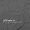 A close-up, draped view of a soft, off-white fabric, likely a blanket, with text overlay. Produktbild-Vorschau