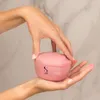 Hands holding a pink jar of hair mask. Voir les images du produit