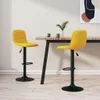 Two yellow bar stools are placed next to a wooden table in a room with light-colored walls and floor. Voir les images du produit