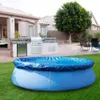 An inflatable pool with a blue cover sits on a green lawn in a backyard setting, with an outdoor kitchen and patio visible in the background. Podgląd zdjęcia produktu