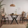 A dining area with a table and chairs, decorated with a plant, a lamp, and artwork. Produktbild-Vorschau