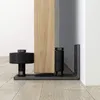 A close-up view of a sliding door floor guide and a wooden door. Náhľad obrázku produktu