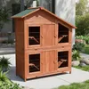 A wooden multi-level hutch for small animals, such as rabbits or guinea pigs, is placed outdoors on a paved patio area. Náhled obrázku produktu