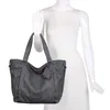 A gray shopper bag displayed on a white mannequin. Voir les images du produit