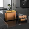 A copper toaster and egg cooker are on a black countertop in a modern kitchen. Produktbild-Vorschau