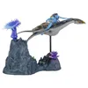 A toy diorama featuring an Avatar character riding a winged creature, with alien flora and rock formations. Produktbild-Vorschau