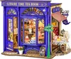 A miniature model of a blue tea room with detailed interior and exterior elements, including furniture, cakes, and signage. Anteprima dell’immagine prodotto